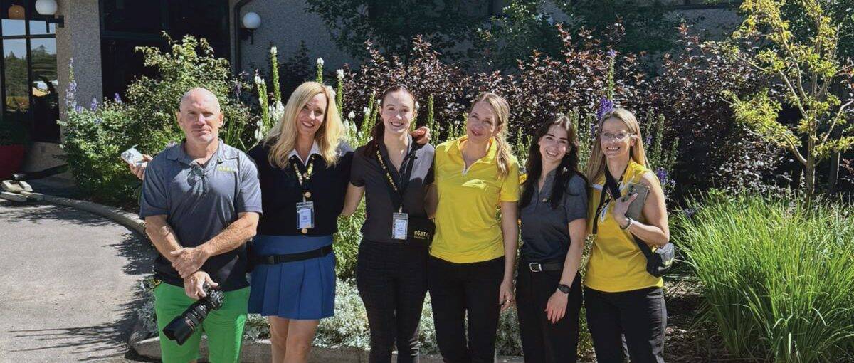 Six people part of a golf team standing together.