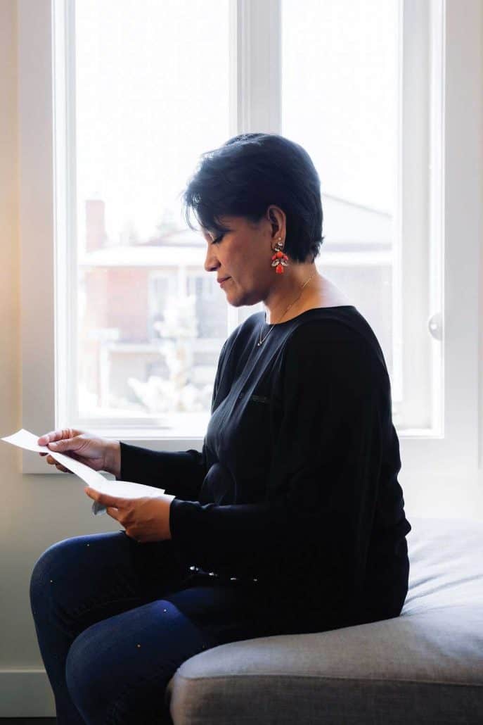Women sitting down reading a letter.