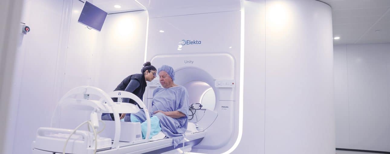 Barry Flavelle in a hospital gown entering an MR-Linac machine.