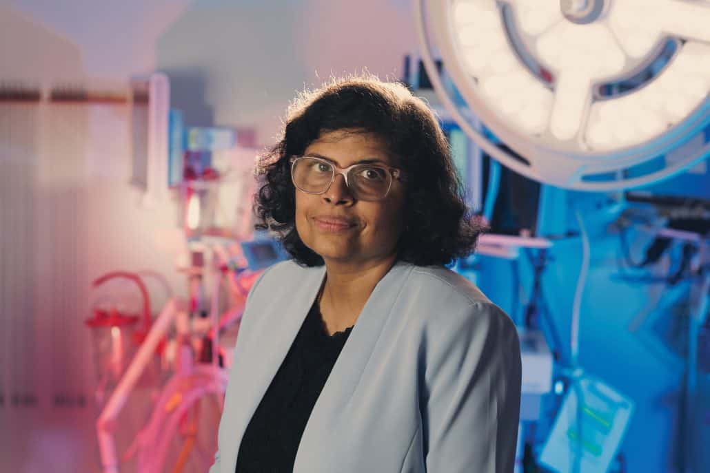 Dr. Geetha Menon in a blue blazer standing an a brachytherapy suite.