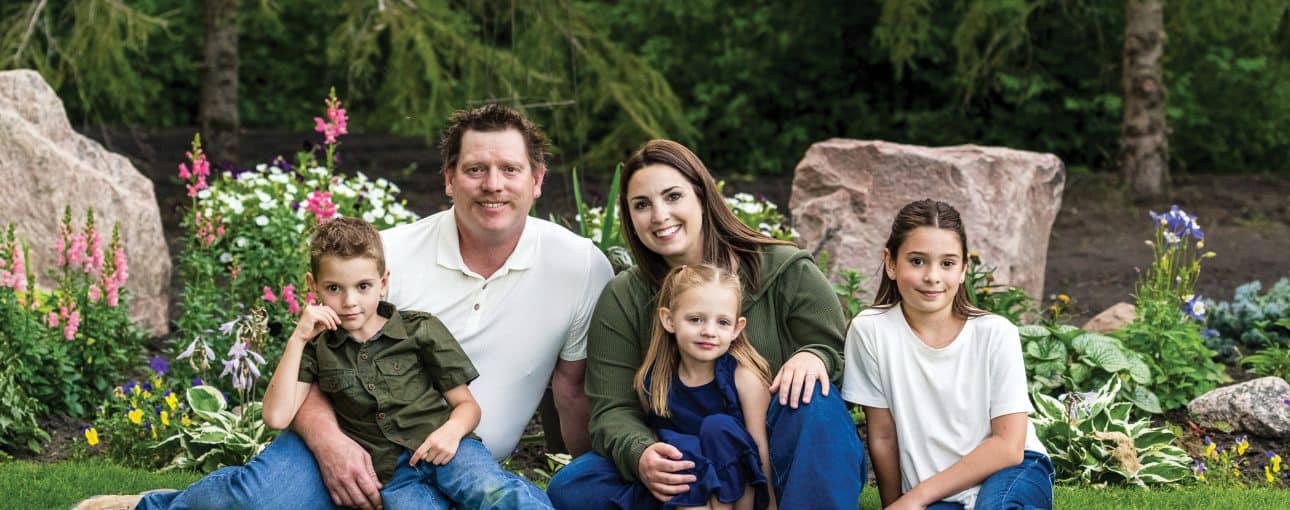 Meet Charlene Broughton. 6 Family picture featuring mom, dad and three kids all sitting on the grass.
