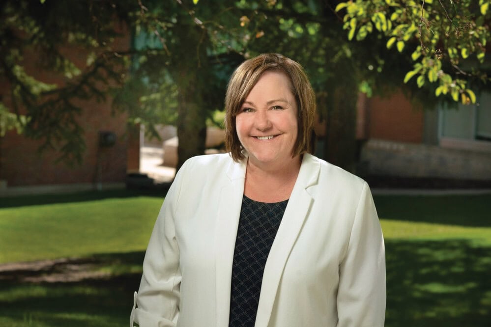 A legacy donation supports community care. 2 Woman in a white blazer smiling.