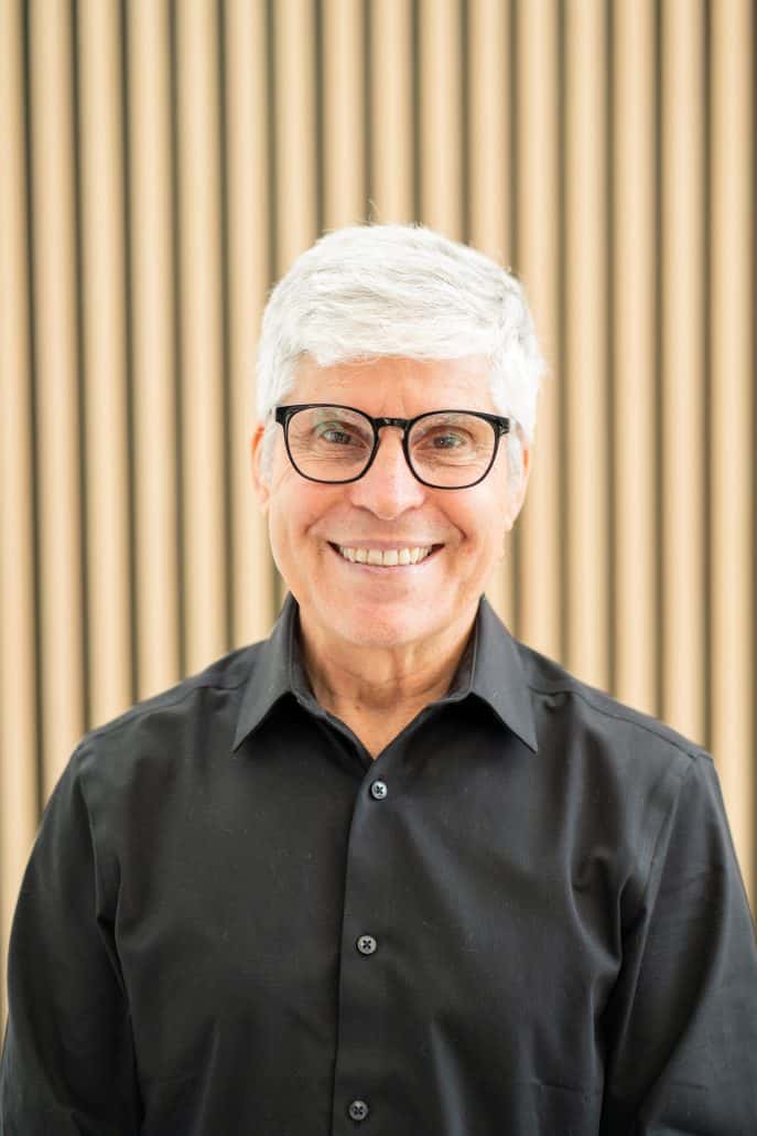 David Dyer, who has white hair and glasses, smiles at the camera.