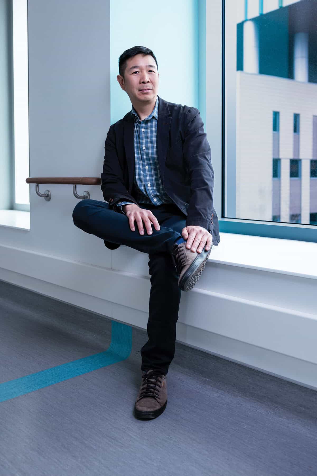 Dr. Jason Tay sits near a window.