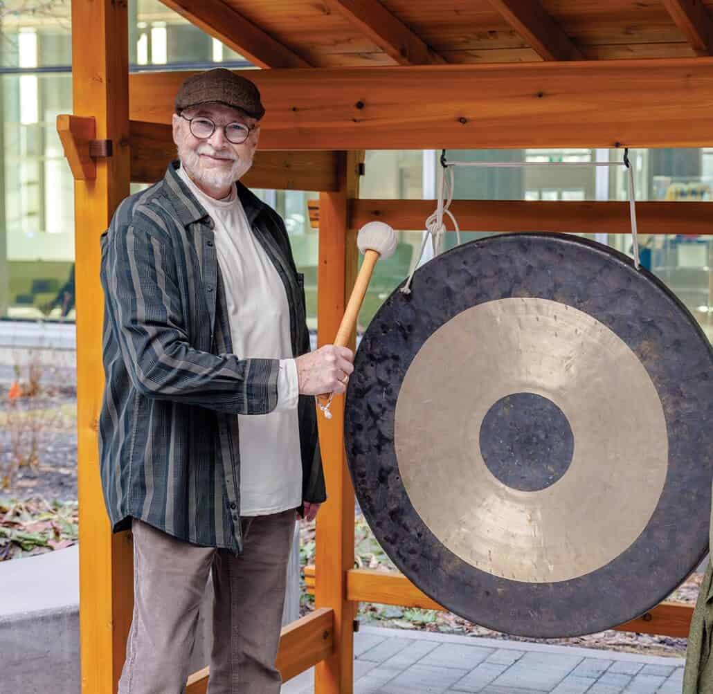 Terry Grant stands next to a gong.