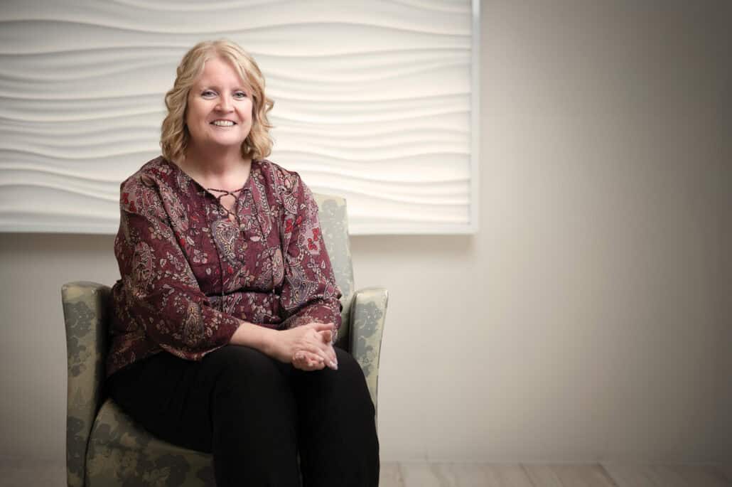 Laurie Laughren sits in a chair with her hands in her lap.
