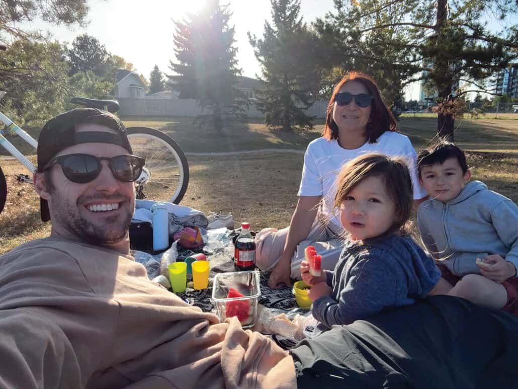 Family with two young boys having a picnic.
