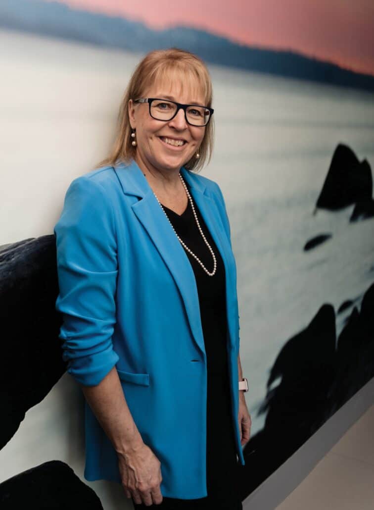 Answering the call for comprehensive support 1 Dr. Linda Watson stands against a wall wearing a blue blazer.