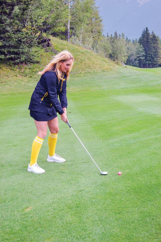 Raising money and awareness for cancer care. 2 Woman about to hit a golf ball.