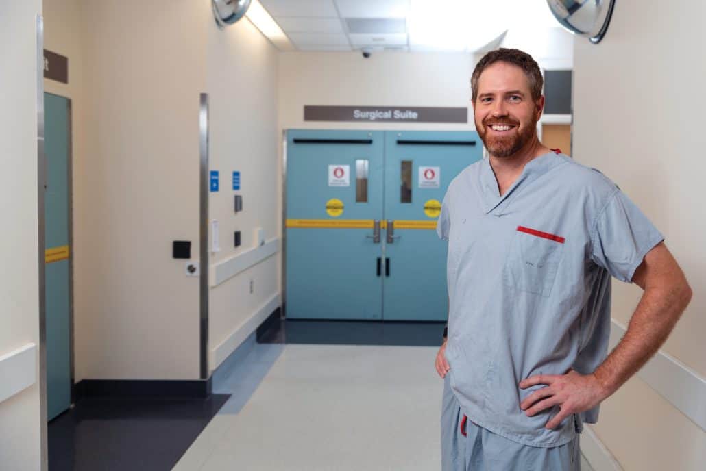 Changing the narrative. 1 Doctor in scrubs standing in a hospital hallway.