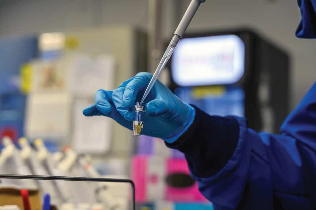 A gloved hand holds laboratory devices.  
