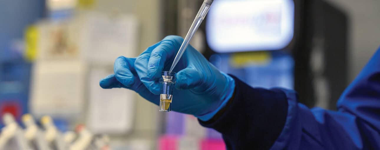 A gloved hand holds laboratory devices.