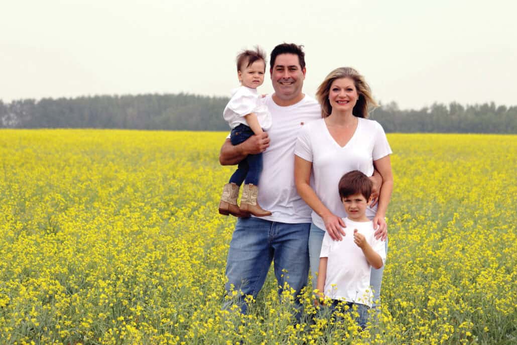 A family photo in a bright yellow canola field. 
