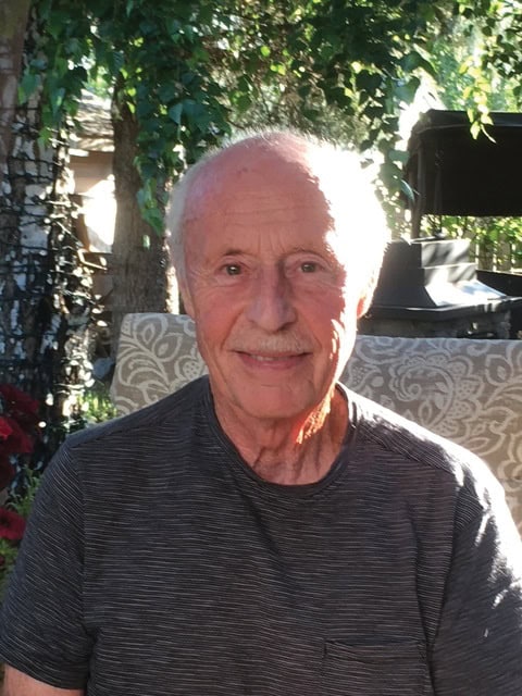 A life lesson in generosity. 1 Elderly man smiling at the camera while sitting outside.