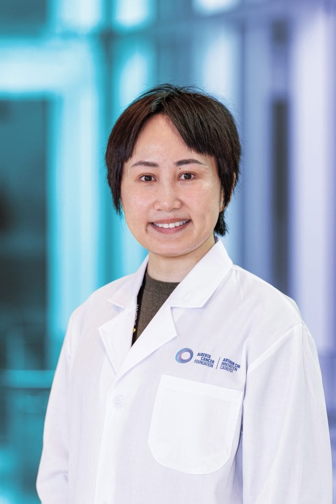 Female doctor wearing a lab coat with a blue and purple background. 