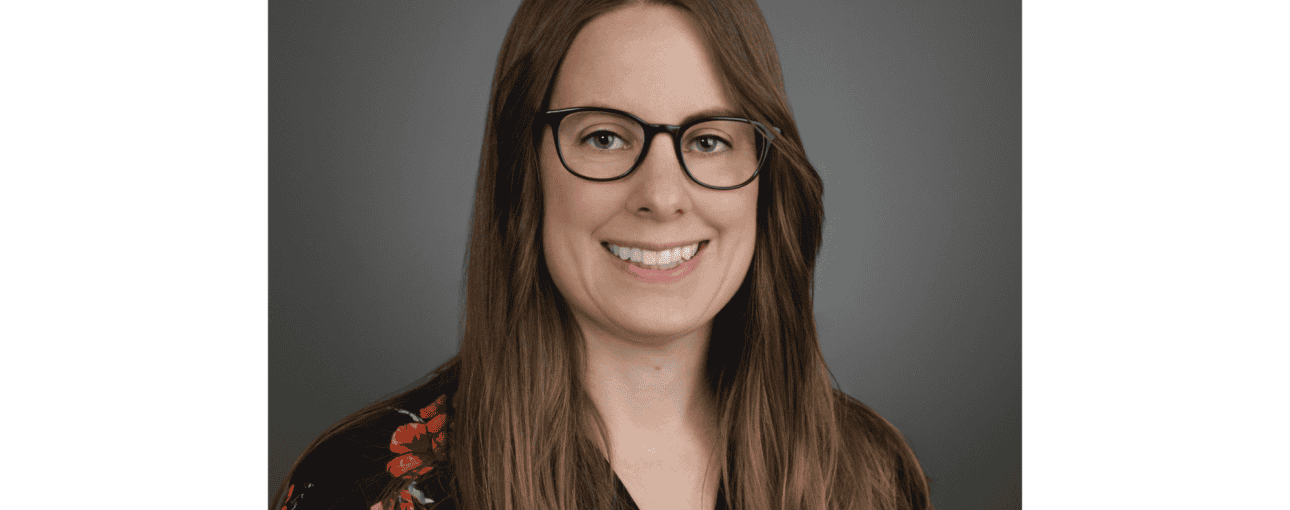Portrait of a woman in a flower shirt smiling at the camera.