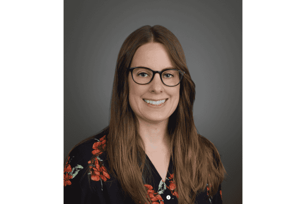 Portrait of a woman in a flower shirt smiling at the camera.