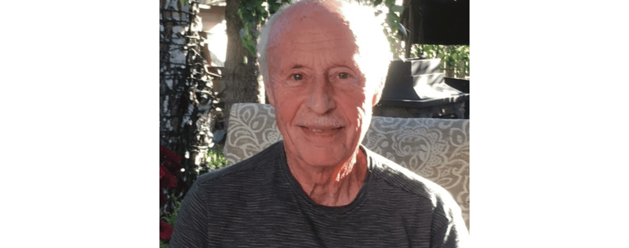 A life lesson in generosity. 1 Elderly man smiling at the camera while sitting outside.